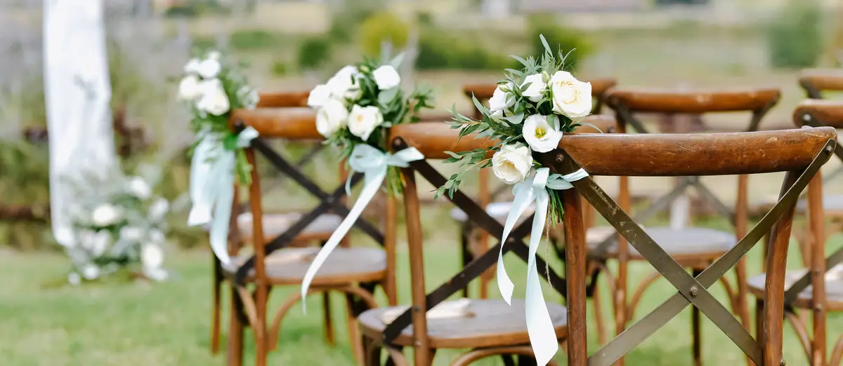 Le sedie della cerimonia decorate con eustoma bianchi e nastri