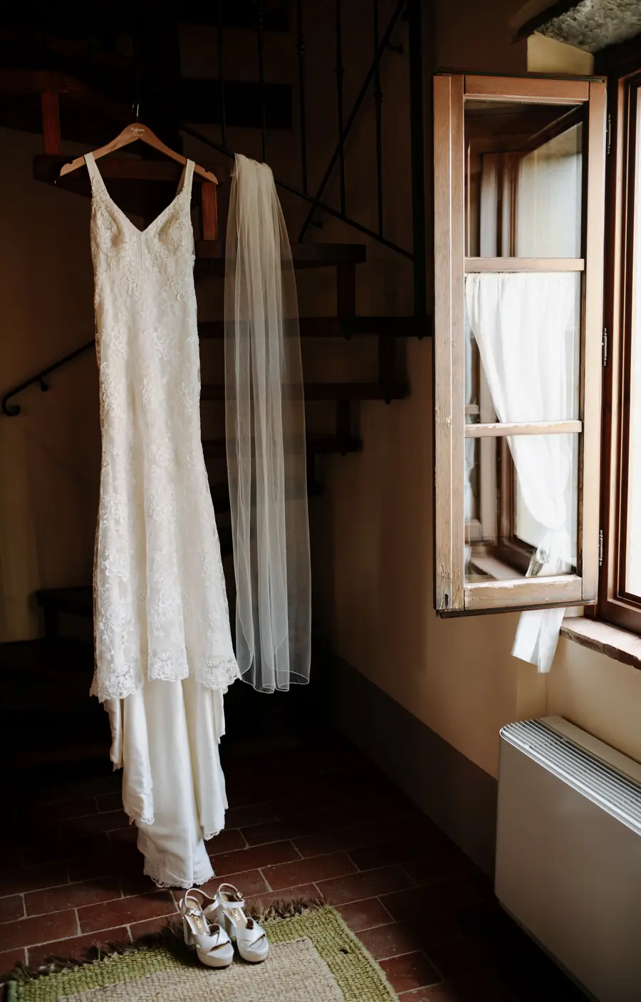 L'abito da sposa appeso accanto alla finestra aperta della stanza
